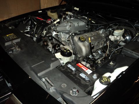2004 Mercury Grand Marquis - The engine bay of a car shows a supercharger and various engine components.