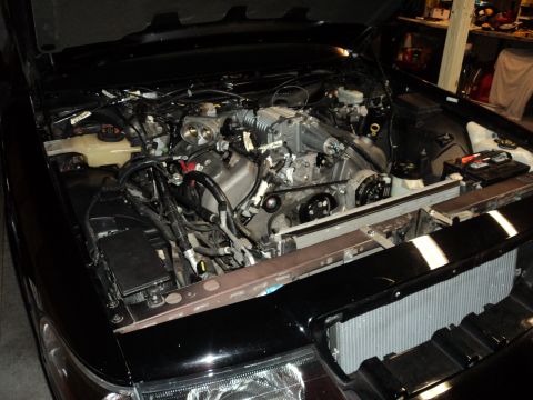 2004 Mercury Grand Marquis - The engine bay of a car, a supercharger and exposed engine components, with a radiator visible.
