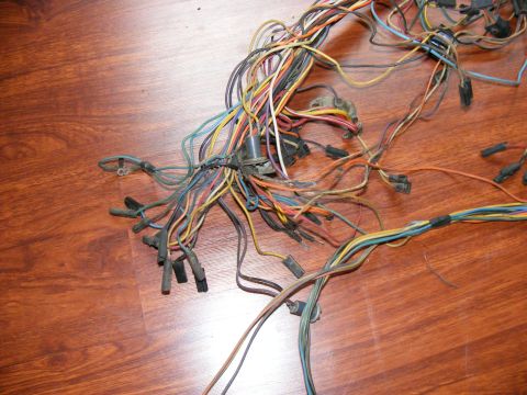Tangled wiring harness with multiple colored wires and connectors on a wooden surface