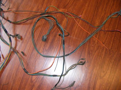 Automotive wiring harness with multiple colored wires and connectors on a wooden surface