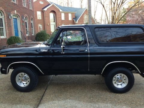 1978 Ford Bronco - A black 1978 Ford Bronco is parked in front of a brick house.
