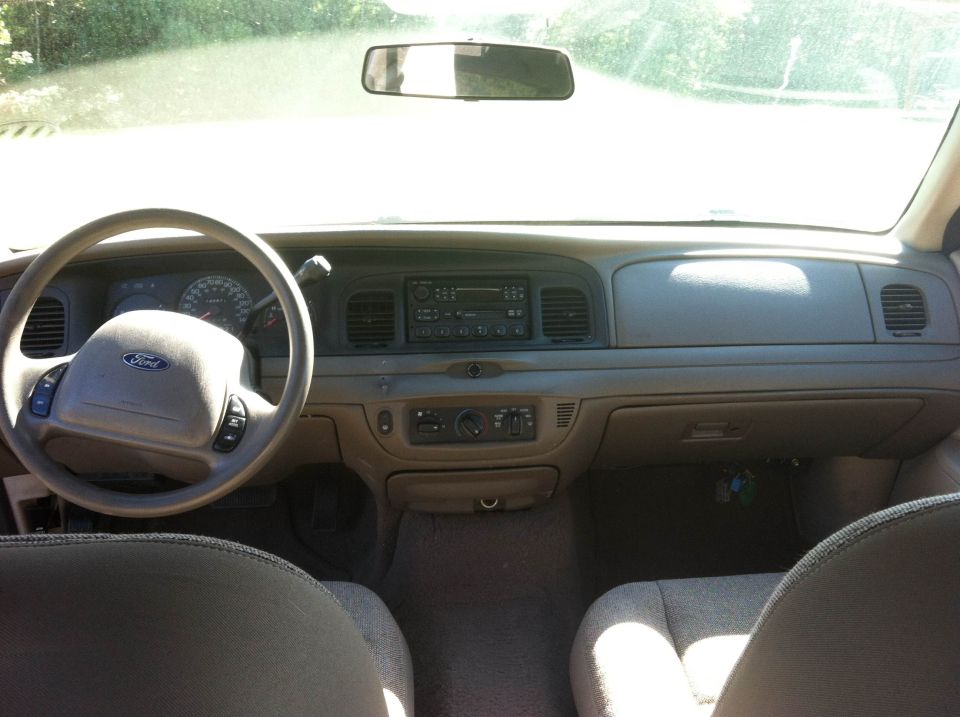 2003 Ford Crown Victoria interior dashboard with tan upholstery, steering wheel, and radio