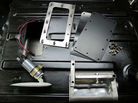 1976 Chevrolet Corvette - A disassembled fuel pump assembly and associated hardware are laid out on a dark, textured surface.