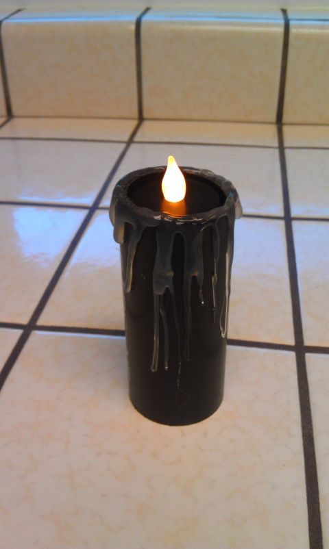 1989 Ford Bronco - A black candle with a faux flame and dripping wax details is placed on a tiled surface.