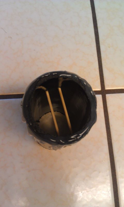1989 Ford Bronco - This object, two wooden sticks within a black cylindrical container, does not appear to be a vehicle part.