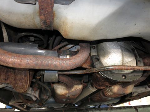 1991 Ford LTD Crown Victoria - A close-up view of the undercarriage reveals the vehicle's exhaust system and rear differential, showing signs of rust.