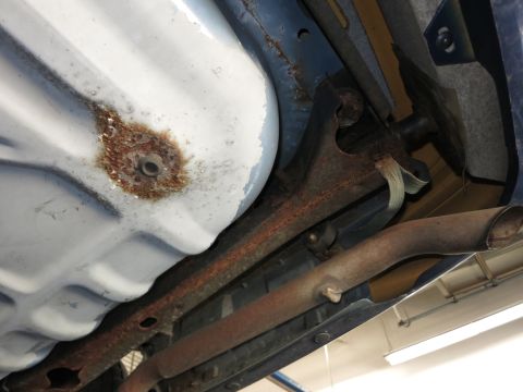 1991 Ford LTD Crown Victoria - Rust is visible on the fuel tank and exhaust components of the vehicle's underside.