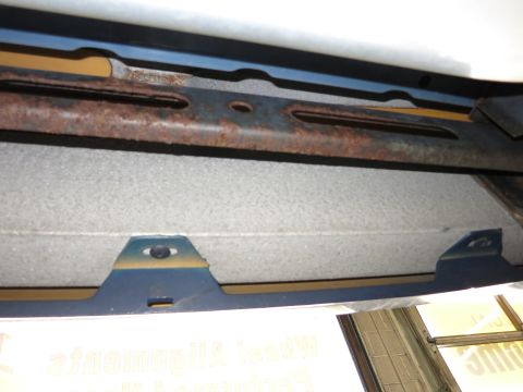 1991 Ford LTD Crown Victoria - Close-up of the undercarriage reveals rusted metal components and a blue bracket.