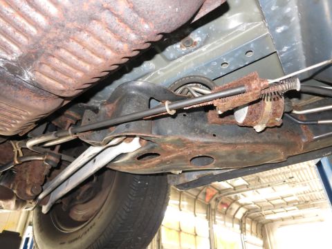 1991 Ford LTD Crown Victoria - The undercarriage of a vehicle displays significant rust on its suspension and exhaust components.