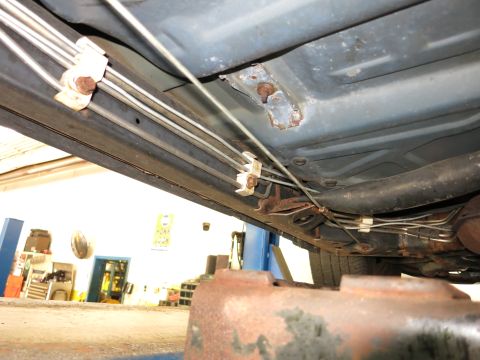 1991 Ford LTD Crown Victoria - Close-up view of the undercarriage of a vehicle, showing brake lines and exhaust components.