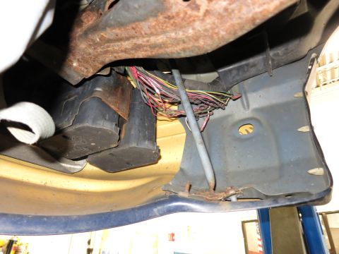 1991 Ford LTD Crown Victoria - Close-up view of the wiring harness and rusted bumper support structure.