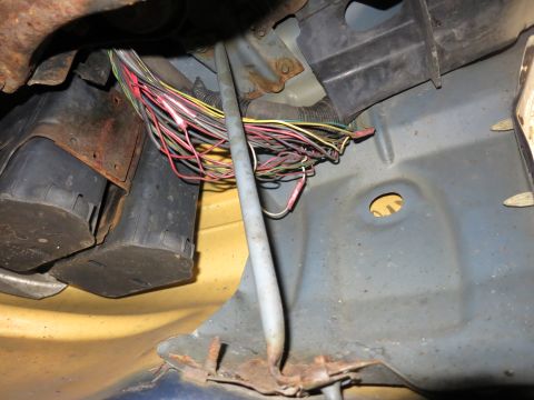 1991 Ford LTD Crown Victoria - A bundle of wires, some with red connectors, are visible in this close-up of a vehicle's undercarriage.