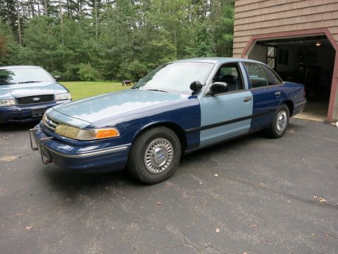 1991 Ford LTD Crown Victoria - Two Ford Crown Victorias are parked in a driveway, one with a two-tone paint job.