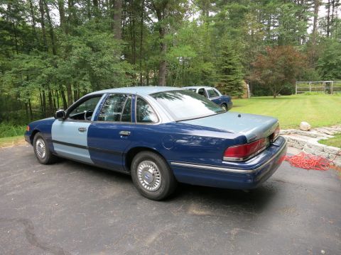 1991 Ford LTD Crown Victoria - A two-tone Ford Crown Victoria is parked in a driveway with another car in the background.