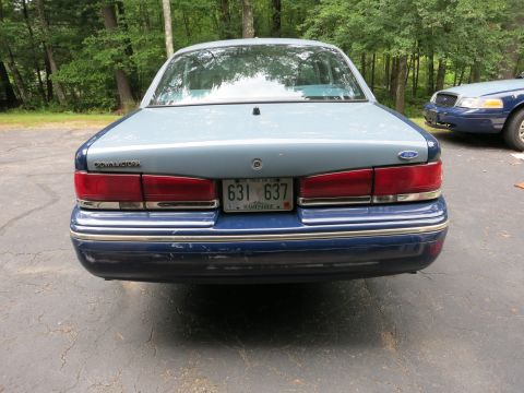 1991 Ford LTD Crown Victoria - The rear of a 1991 Ford Crown Victoria LTD shows its distinctive taillights and dual-tone paint job, with another similar vehicle visible i…