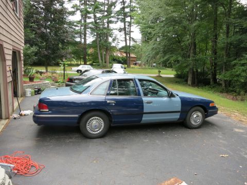 1991 Ford LTD Crown Victoria - A two-tone Ford Crown Victoria is parked in a driveway next to a house.