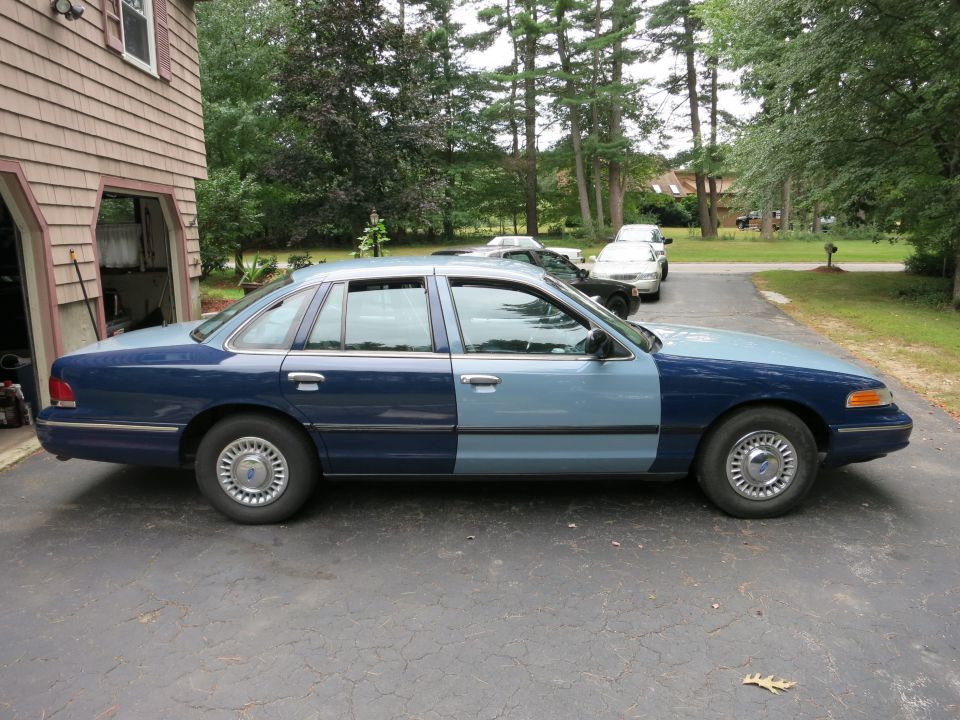 Two-tone blue sedan, light blue front half, dark blue rear half, parked on driveway