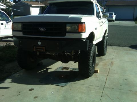 1988 Ford Bronco - This lifted 1987 Ford Bronco features a black aftermarket bumper with a winch and large off-road tires.