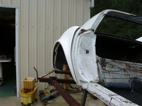 1976 Chevrolet Corvette - The body of a car is shown on a stand, undergoing restoration or repair.