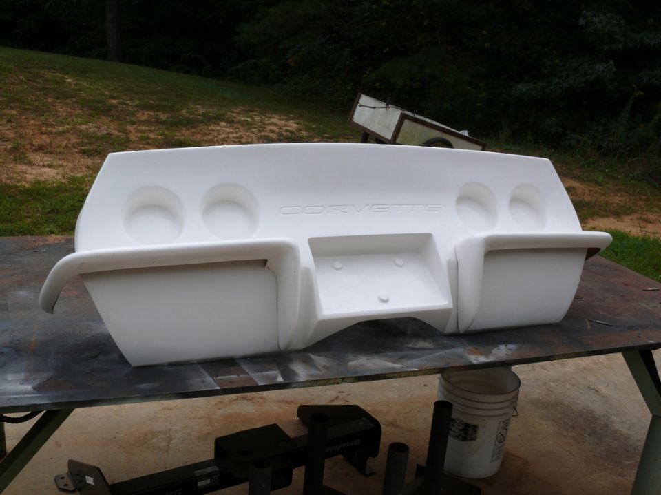 White Corvette rear bumper with four taillight cutouts and 'CORVETTE' embossed text