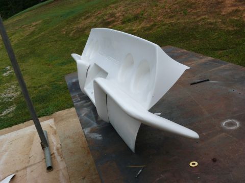 1976 Chevrolet Corvette - A white Corvette body panel is shown outdoors, with the word "CORVETTE" embossed on its surface.
