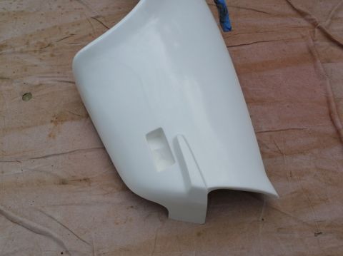 1976 Chevrolet Corvette - This white car fender part features a distinctive rectangular cutout and a curved lower edge.