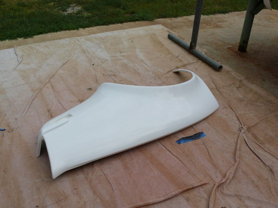 White car fender part laid out on a drop cloth