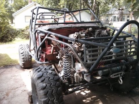 1986 Ford Bronco - Custom off-road vehicle with a roll cage and large tires, a Ford emblem on the front grille.