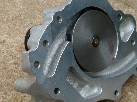 1990 Ford Bronco - Close-up view of a metal water pump, showing the impeller and mounting holes.