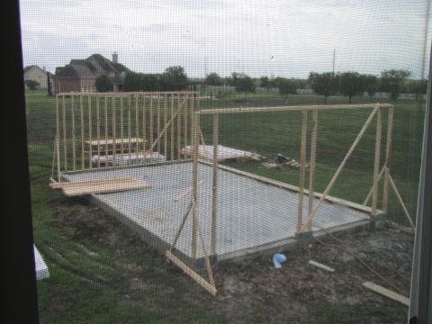 1995 Ford Bronco - Framing for a new house is in progress on a concrete foundation, with building materials scattered around the site.