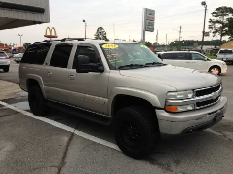 2005 Chevrolet Suburban - Silver 2005 Chevrolet Suburban SUV parked outside a dealership, with other vehicles visible.