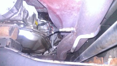 2005 Chevrolet Suburban - Underside view of an exhaust system with an oxygen sensor and transmission pan visible. The image includes a watermark for SuperMotors.net.