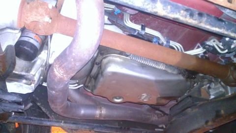 2005 Chevrolet Suburban - Underside view shows exhaust pipes and transmission pan, with some rust visible on components.