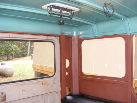 Interior view of a vehicle with teal ceiling and brown panels