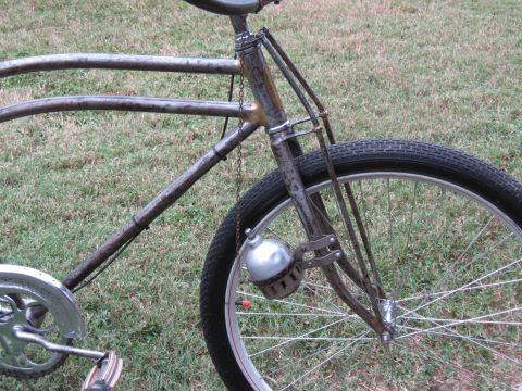 close-up of old bicycle frame, front fork, and wheel with a bell