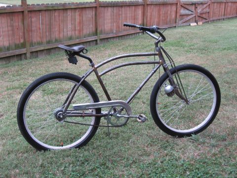 Rusty bicycle with a brown leather seat and a silver chain guard, viewed from the side