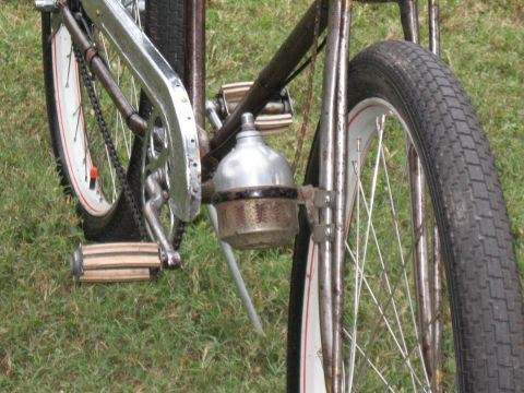 Close-up of a vintage bicycle's front wheel, pedals, and chain guard