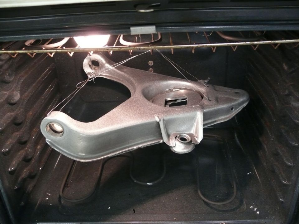 Control arm suspended by wires inside an oven