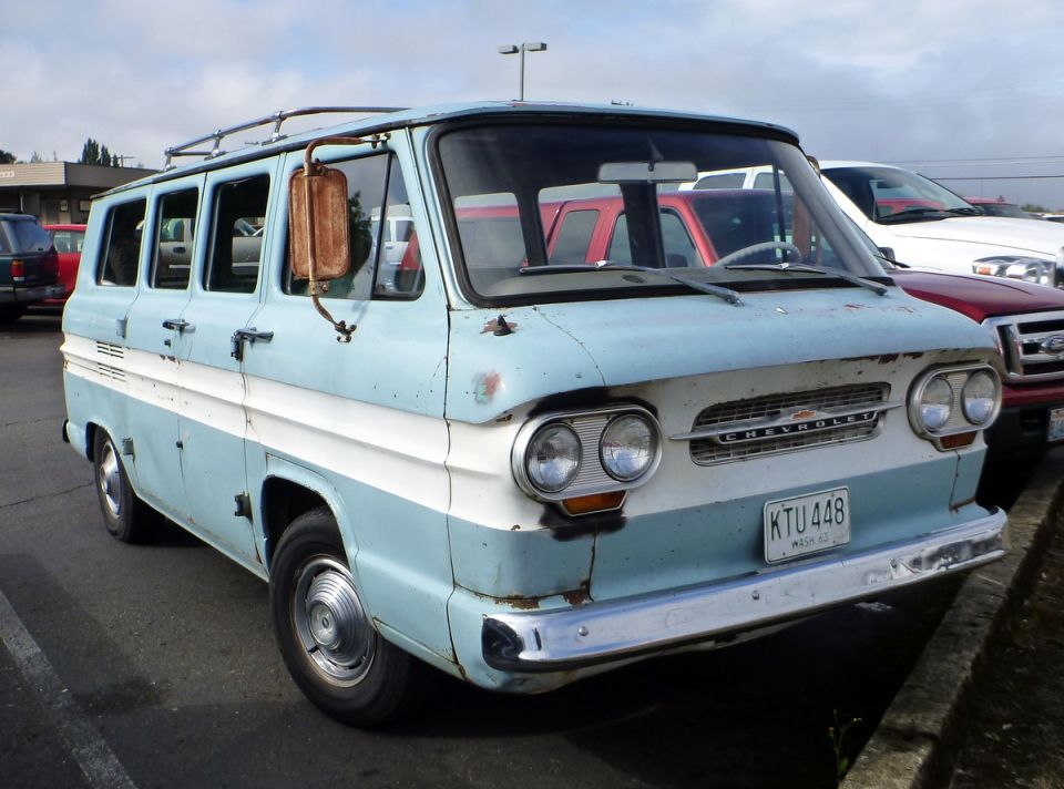 Light blue and white Chevrolet van with a rusty side mirror and roof rack. License plate reads KTU 448