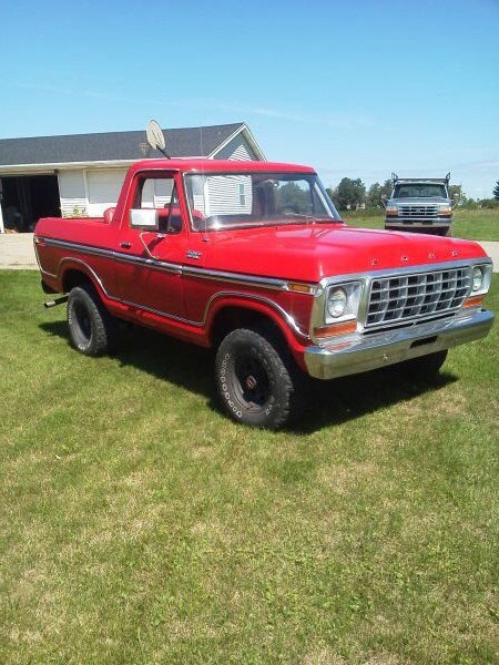1978 Ford Bronco - This red 1978 Ford Bronco is parked on a grassy lawn with a house and another truck visible.