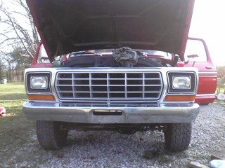 1978 Ford Bronco - Front view of a 1978 Ford Bronco with the hood open, showing the grille and headlights.