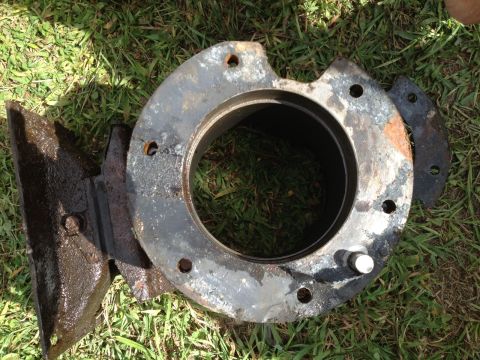 1978 Ford Bronco - A rusty metal part, likely from a vehicle's hub assembly, rests on a grassy surface.
