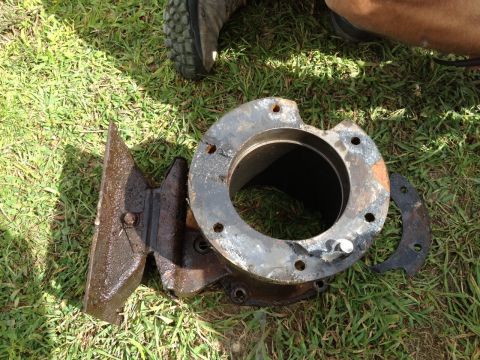 1978 Ford Bronco - This appears to be a heavily rusted metal component, possibly from a vehicle's drivetrain, resting on a grassy surface.