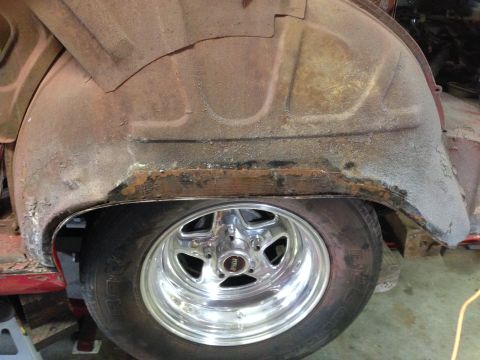 1964 Ford Fairlane - Close-up of a rusty wheel well and tire, showing significant corrosion.