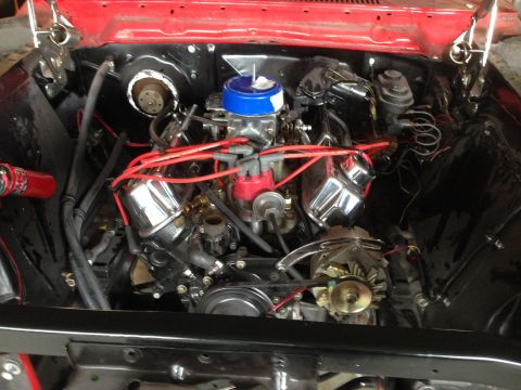 1964 Ford Fairlane - The engine bay of a 1964 Ford Fairlane is displayed, a V8 engine with polished chrome valve covers and bright red spark plug wires.