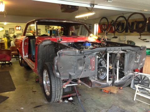 1964 Ford Fairlane - This red coupe is in a garage with its front end removed for restoration work.