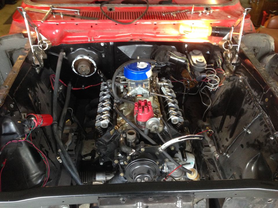 V8 engine bay with carburetor, distributor, and brake master cylinder visible