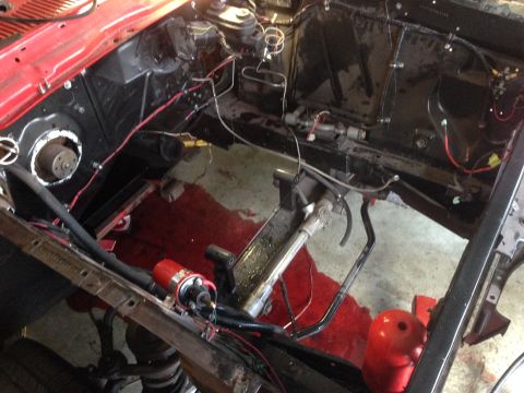 1964 Ford Fairlane - The engine bay of a 1964 Ford Fairlane shows exposed components and wiring, indicating ongoing work.