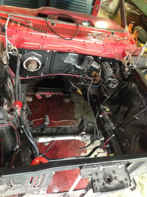 1964 Ford Fairlane - The engine bay of a car is shown with various components and wiring, indicating a restoration or repair process.
