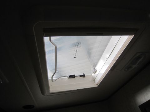 2008 Ford F-450 - Interior view of an RV skylight with its shade partially down and a manual latch.